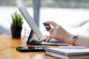 Young Asian women hand using a credit card and tablet computer payments for online shopping, Online shopping, digital banking, E-commerce concept.
