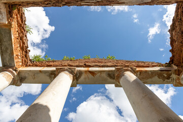 crumbling columns of a century-old palace against a blue sky