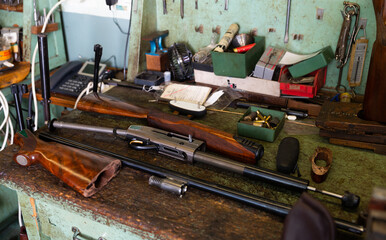 Disassembled automatic rifle on the table of the weapons workshop