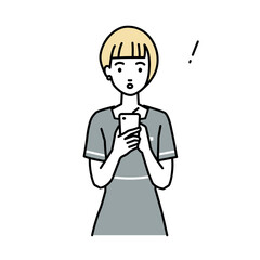 立ってスマートフォンを操作して何かに気づいて驚いたエステ店員の女性