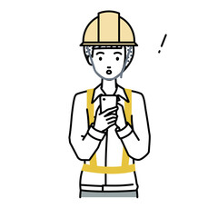 立ってスマートフォンを操作して何かに気づいて驚いた工事現場の女性