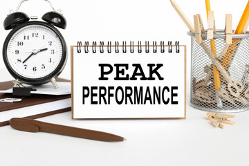 PEAK PERFORMANCE. notepad with white sheets on a white background. business concept