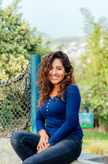Obraz premium Beautiful young woman sitting on a stone bench in the park.