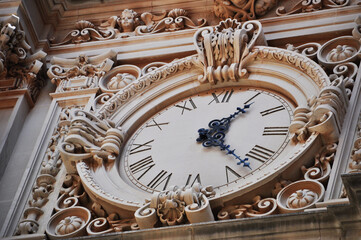 Large clock with stone carvings. Clock on the old building. Background