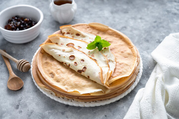 Thin, french crepes or pancakes on grey background. Delicious food for breakfast