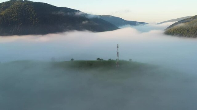 Aerial view on amazing flowing morning fog spreads over green meadows in autumn mountains. Ukrainian Carpathian mountains. UHD 4k video