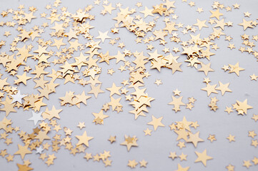 Gold stars shiny glitter on a white background, selective focus