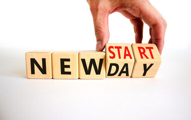 New day and start symbol. Businessman turns wooden cubes and changes words 'new day' to 'new start'. Beautiful white table, white background. Copy space. Business, new day and start concept.