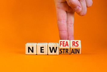 Mutated covid-19 strain virus symbol. Doctor turns cubes and changes words new strain to new fears. Beautiful orange table, orange background. Medical new mutated covid-19 strain concept. Copy space.
