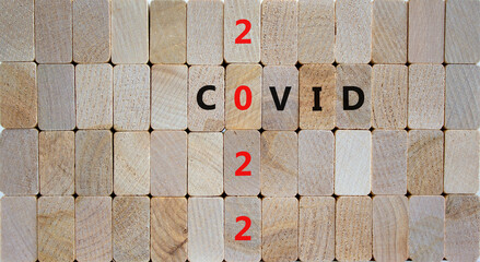 Symbol of covid-19 pandemic in 2022. Wooden blocks with words 'covid 2022'. Beautiful wooden background, copy space. Medical, covid-19 pandemic in 2022 concept.