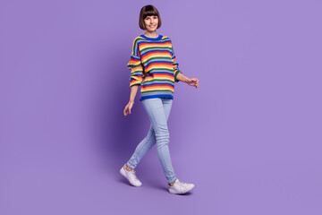 Photo of pretty cheerful positive lady walk travel wear striped pullover jeans shoes isolated violet color background