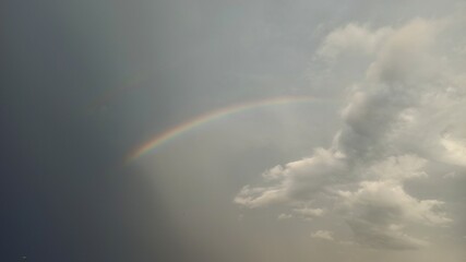 rainbow between clouds and black sky