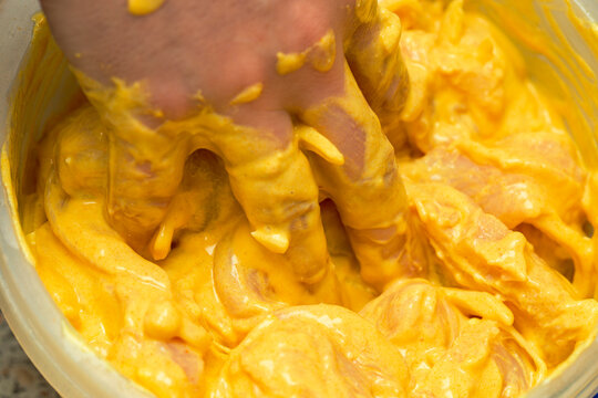 Hand Mixing In A Bowl Chicken Breast With Curcuma Marinade , Selective Focus Macro