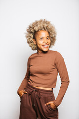 Fototapeta na wymiar Portrait of Smiling Young woman wearing brown clothes while standing Against White Background