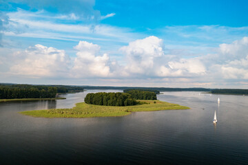 Obraz premium Aerial view of green islands and clouds at summer sunny day. Masurian Lake District in Poland. 