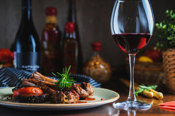 Fried ribs with a glass of red wine on a table in a restaurant close-up