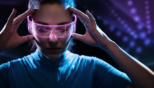 Concept of future technology or entertainment system, virtual reality. Female portrait lit by HUD interface