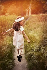 Poster Portrait of cute kid girl with bloom flowers. Nature outdoor. Child in nature concept. © konradbak