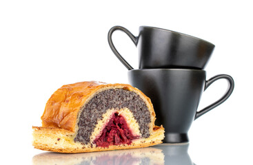 One piece of cherry poppy strudel with two black cups, close-up, isolated on white.