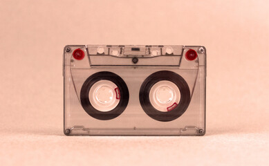 Fototapeta premium Retro audio cassette stands on a light background under orange lighting