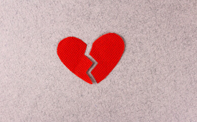 Broken red heart on a gray background