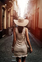 Poster Happy young woman with straw hat enjoying her summer holidays © konradbak