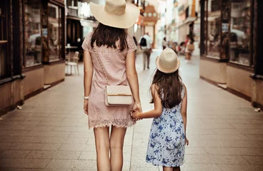 Fotobehang Loving mother and her cute daughter exploring city on a sunny summer day. © konradbak