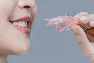 A woman is wearing a retainer on her teeth.