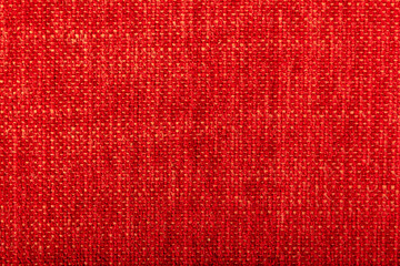 Factory fabric of red color with yellow threads interspersed. Close-up long and wide texture of natural red fabric. Fabric texture of natural cotton or linen textile material. Red canvas background