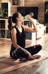 Schilderijen op glas Fitness girl with yoga mat drink water © konradbak