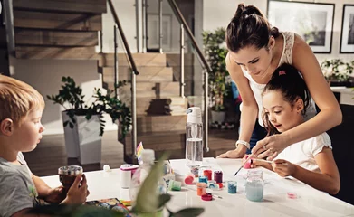 Foto auf Acrylglas Young mom and her kids having fun and painting at home © konradbak