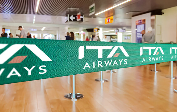 Green ribbon barrier with the ITA airways logo inside the Leonardo da Vinci international airport in Rome Fiumicino in Italy