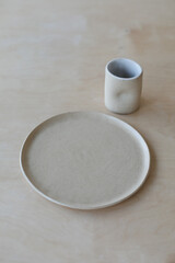 ceramic cup and plates on a wooden table top view. minimalist set of handmade ceramic tableware and pottery