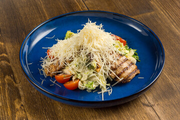 Dish of fried meat with fresh vegetables sprinkled with fresh grated cheese