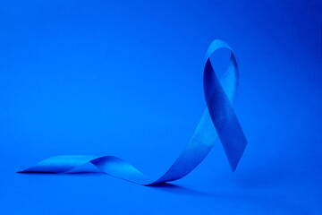 November. Awareness of men health in November with blue prostate cancer ribbon isolated on deep...