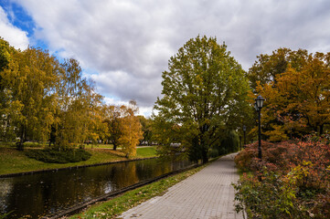 Autumn park with canal and pavement. Cloudy day. Riga, Latvia.