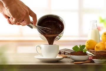 Foto op Aluminium Man filling a cup of fresh hot chocolate from saucepan © Davizro Photography