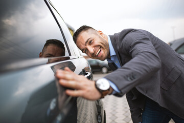 A young businessman anjoys buying a new car.