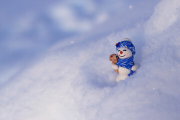 Fototapeta na wymiar Smiling toy snowman on the frosty snow. Christmas card with copy space. Winter holidays background for congratulations.