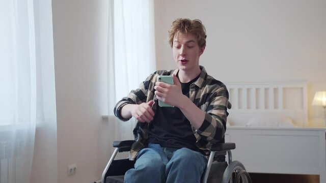 A beautiful disabled man is talking with his friend on the Internet 