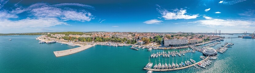 Fototapeta premium Drone panorama of the Croatian coastal city of Pula taken during the day above the harbor