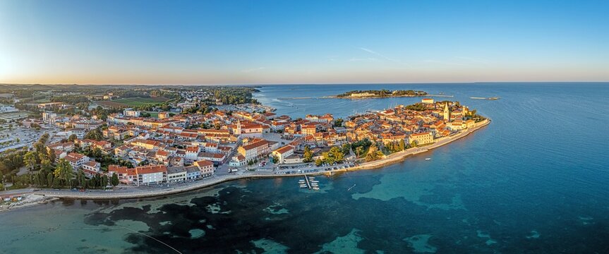 Drone panorama of Croatian coastal town Porec with harbor and promenade during sunrise