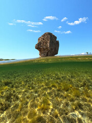 Underwater split photo of iconic rock formations in Pouria beach an old stone factory, Skyros island, Sporades, Greece