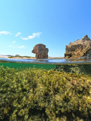Underwater split photo of iconic rock formations in Pouria beach an old stone factory, Skyros island, Sporades, Greece