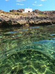 Underwater split photo of iconic small chapel of Agios Ermolaos built in a small islet, Skyros island, Sporades, Greece