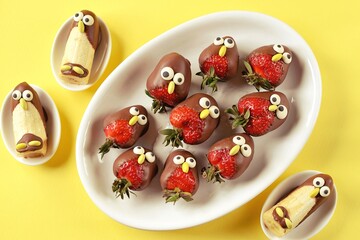 Strawberries and bananas in chocolate in the form of birds. Cute idea for kids party. 