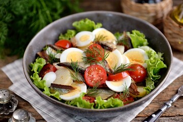 Salad with smoked fish, potatoes, cherry tomatoes and a boiled egg.