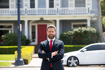 Entrepreneur, business portrait. Businessman standing proud with arms crossed outside.