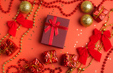 Red Christmas gifts and Christmas trees on a red background. An article about the New year and Christmas. The choice of gifts. A red gift .