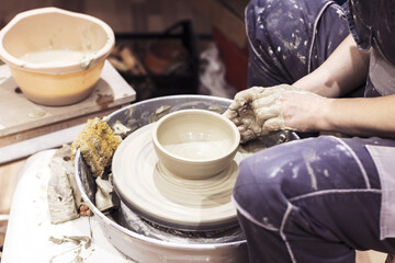 Fototapeta na wymiar Pottery workshop. Female ceramic artist molding clay on pottery wheel. Creative handmade craft.